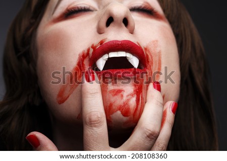 Female vampire licking blood after biting