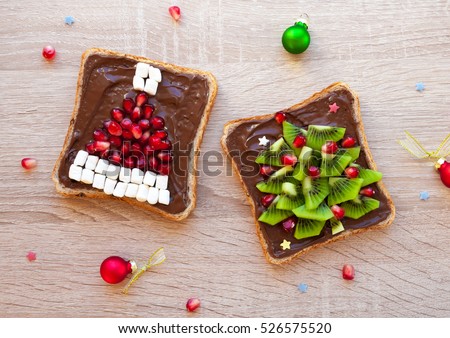 Chocolate sandwich with pomegranate and marshmallow Santa hat and kiwi Christmas tree - creative idea for kids breakfast, dessert or holiday meal, Christmas food art