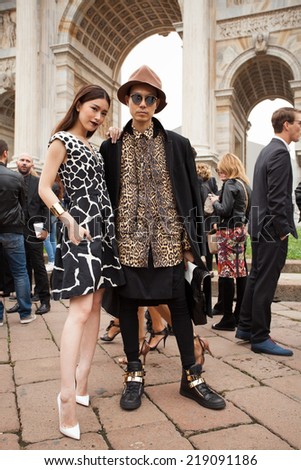 MILAN, ITALY - SEPTEMBER 20, 2014: Fashion Asian couple poses outside Cavalli fashion shows building in Milan, Italy at Milan Fashion Week 2014