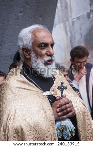 YEREVAN, ARMENIA - 24 APRIL, 2011: An undefined Armenian priest holds a cross in the Armenian Genoside memorial Tsitsernakaberd