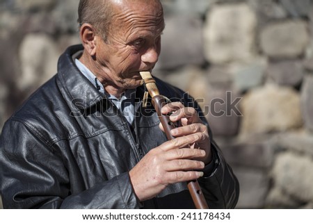 GEGHARD, ARMENIA - NOVEMBER 8, 2014: Old Armenian musician playing traditional music on traditional duduk