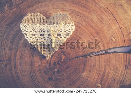 Decorative hand made valentine heart on a piece of cracked wood - soft colored photo