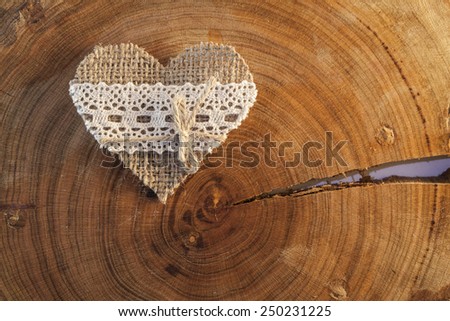 Decorative hand made valentine heart on a piece of cracked wood