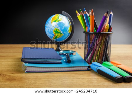 Globe, notebook stack and pencils. Schoolchild and student studies accessories.