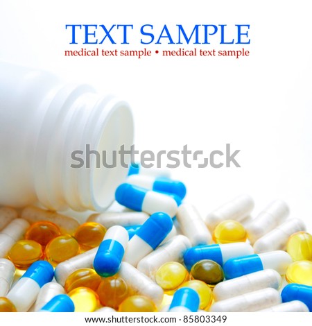 Open pill bottle with medicine spilling out of it isolated on white