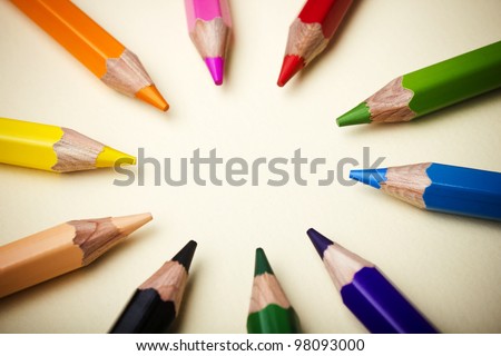 Color pencils in arrange in color wheel colors on paper background