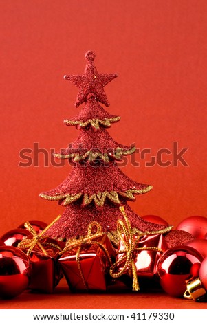 Red sparkly christmas tree, red globes and red gift boxes with golden ribbon