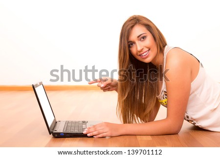 Beautiful teenager relaxing at her living room with the company of a last generation computer