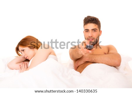 Couple in bed - Man is watching television and woman doesn\'t like it