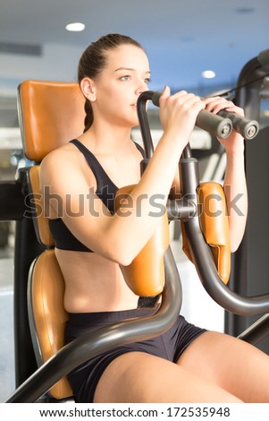 A young and beautiful woman working out at the gym at the end of the day with sunset light