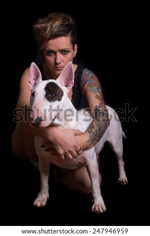 Studio shot of a tattooed woman with her friend, a bull terrier