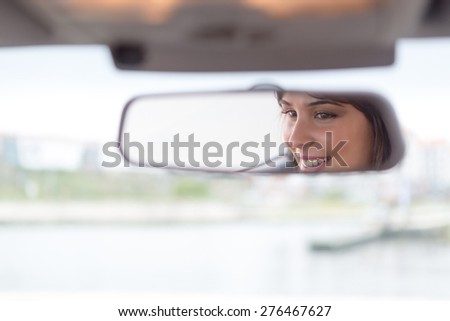 Happy woman driving - reflex in the mirror