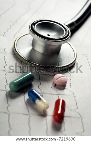 an old stethoscope and some pills on an electrocardiogram sheet