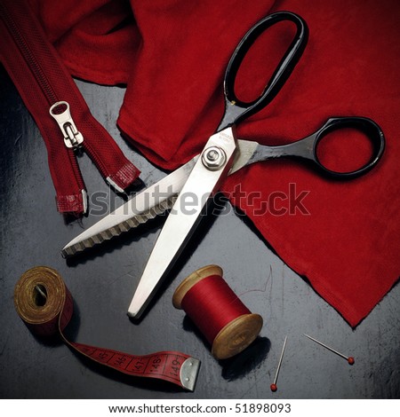 tailor\'s tools - scissors, spool of thread, measuring tape, pins, zipper, etc...