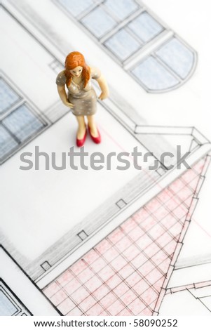 a female figurine standing on her house blueprint (copyright notice: it is a blueprint of my own house - i paid for design)