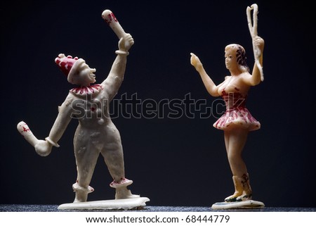 vintage circus figurines - juggler and a lion tamer - against dark background