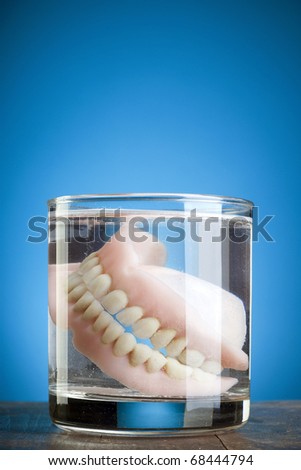 stock photo : a pair of dentures in a glass of water