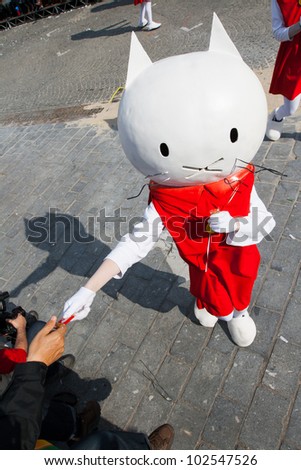 IEPER, BELGIUM - MAY 13, 2012: Musti cat character hands out a cookie to spectators on the 43th edition of the Cat Parade in Ieper, Belgium on May 13, 2012