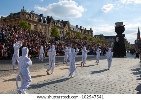 IEPER, BELGIUM - MAY 13, 2012: People in white cat costumes follow the statue of Ieper cat on the 43th edition of the Cat Parade in Ieper, Belgium on May 13, 2012
