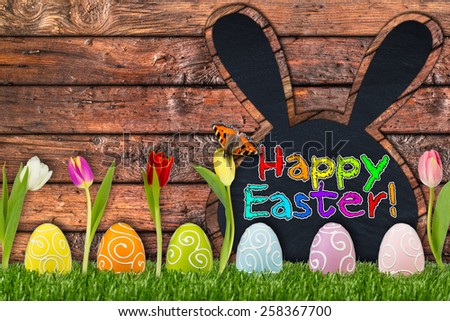 easter eggs and tulips in front of wooden background