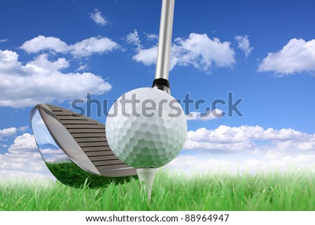 golf club with ball and tee on green in front of blue cloudy sky
