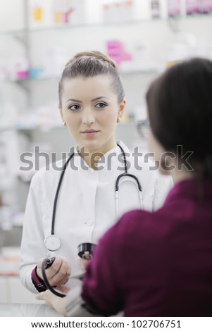 doctor checking blood pressure and heart rate in a hospital or in pharmacy with young female patient