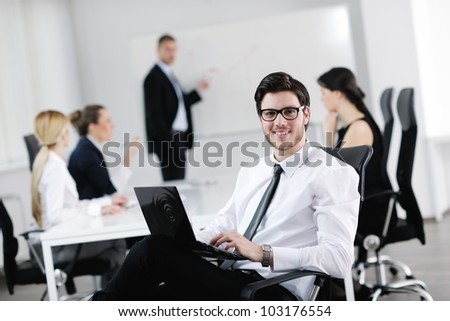 Portrait of a handsome young business man with people  in background at office meeting