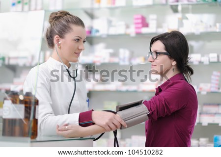 doctor checking blood pressure and heart rate in a hospital or in pharmacy with young female patient