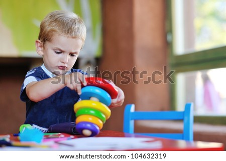 happy little child play game and have fun, education lessons in colorful kinder garden playground indoors