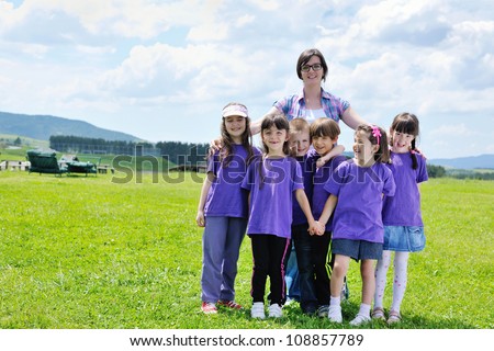 happy preschool  kids group have fun and play game  on outdoor classes in nature