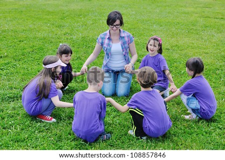 happy preschool  kids group have fun and play game  on outdoor classes in nature
