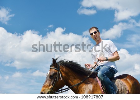 young man ride horse farm animal with blue sky in background
