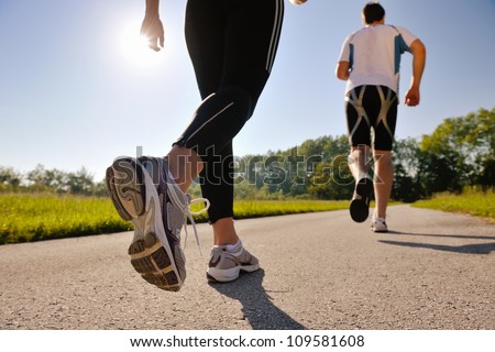 Young couple jogging in park at morning Health and fitness Young couple jogging in park at morning Health and fitness