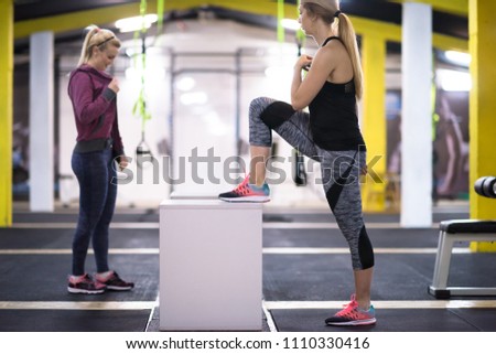 group of young healthy athletic people training jumping on fit box at cross fitness gym