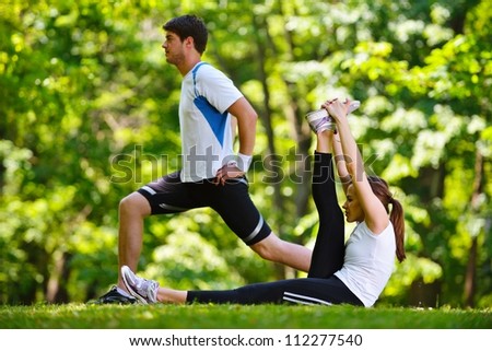 young health couple doing stretching exercise relaxing and warm up after jogging and running in park young health couple doing stretching exercise relaxing and warm up after jogging and running in park