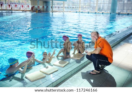 happy childrens group  at swimming pool class  learning to swim