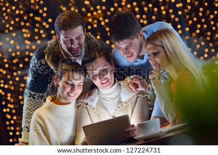 Group of happy people looking at a tablet computer