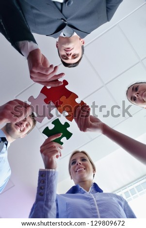 Group of business people assembling jigsaw puzzle and represent team support and help concept
