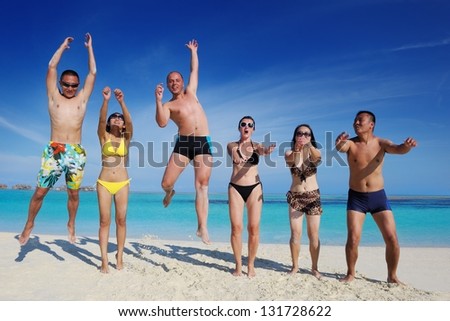 group of happy young people have fun and joy at the  white sand  beach on beautiful summer  day