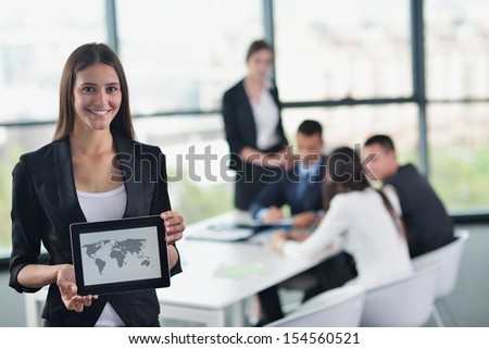 happy young business woman  with her staff,  people group in background at modern bright office indoors