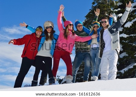 happy friends have fun at winter on fresh snow, healthy young people group outdoor