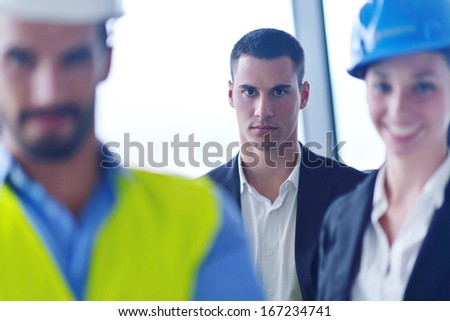business people group on meeting and presentation  in bright modern office with construction engineer architect and worker looking building model and blueprint  plans