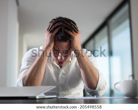 frustrated with problems young business man working on laptop computer at home