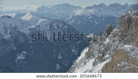 winter landscape with ski chairlift cabin and mountain covered with snow at sunny day