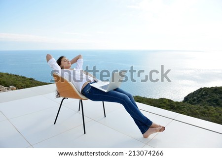 beautiful young woman relax and work on laptop computer while working on laptop computer and read book at home