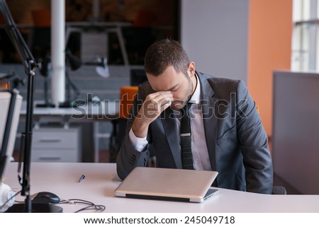 frustrated young business man working on laptop computer at office