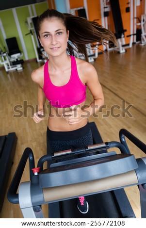 sport, fitness, lifestyle, technology and people concept - smiling woman exercising on treadmill in gym