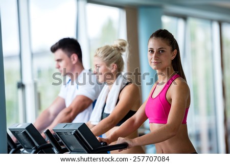 Beautiful group of young women friends  exercising on a treadmill at the bright modern gym