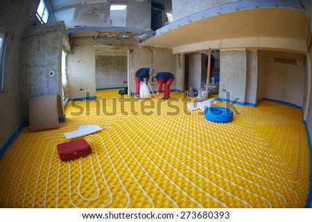 group of workers installing underfloor heating and colling in modern home