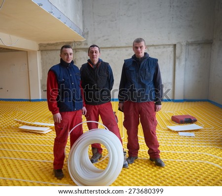 group of workers installing underfloor heating and colling in modern home